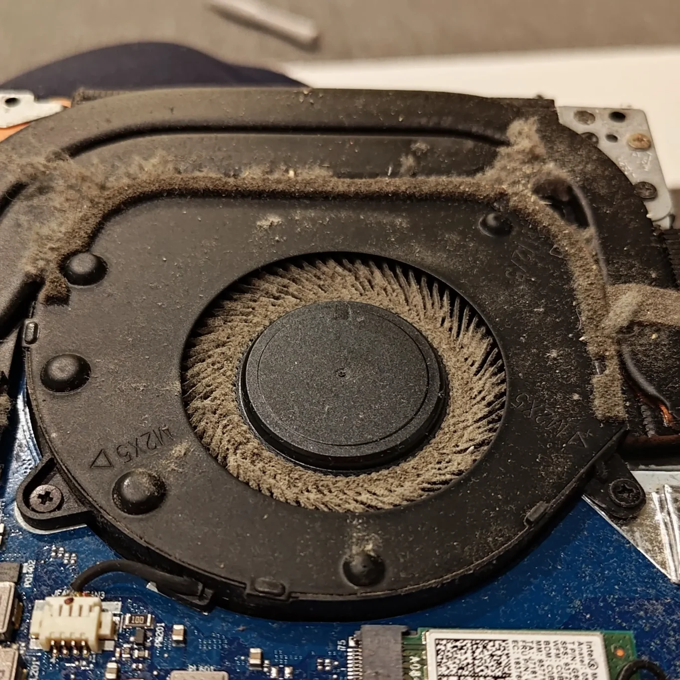 Laptop Fan Clogged With Hair Fibres And Fine Dust Forcing The Cooling System To Work Harder