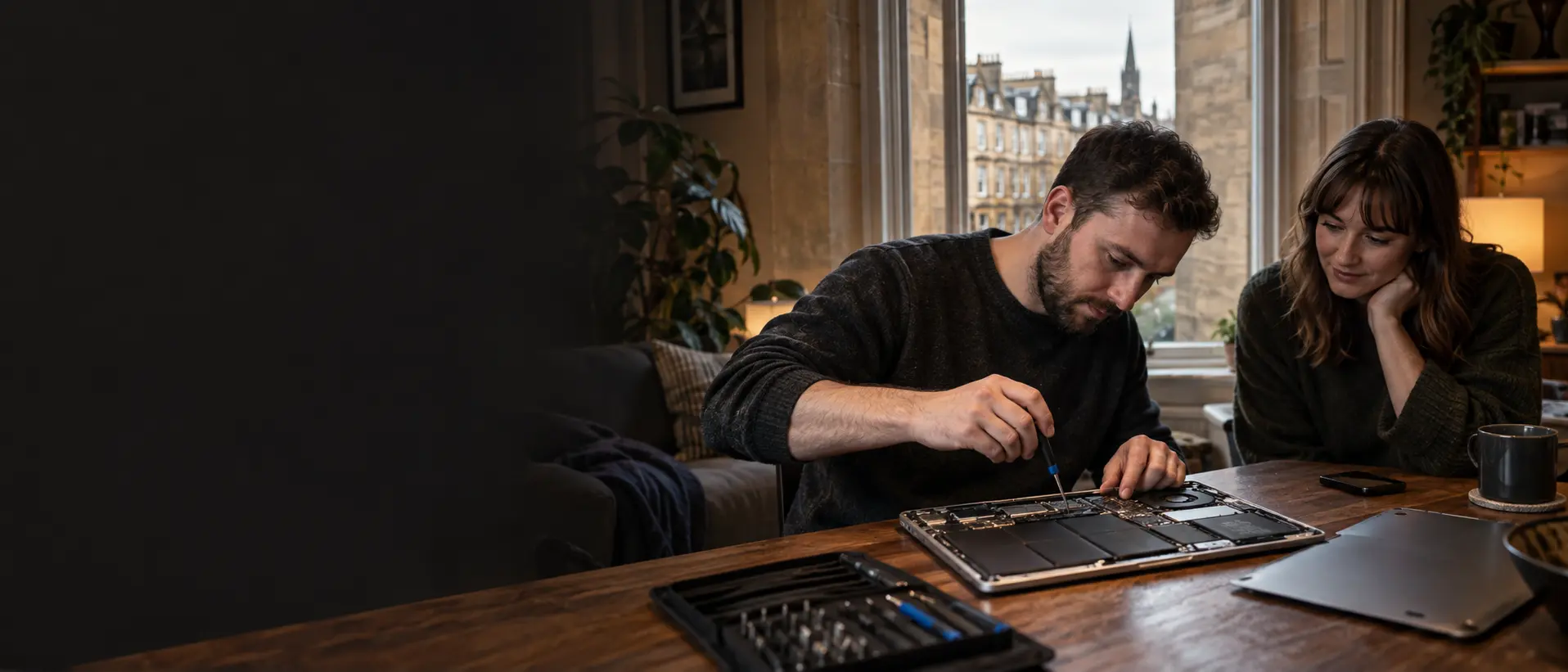 Computer repair engineer working on a laptop in a Glasgow home