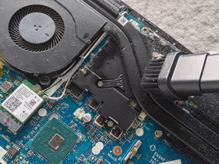 Dust being brushed from Acer Nitro AN517-51 board near fan and heat pipe
