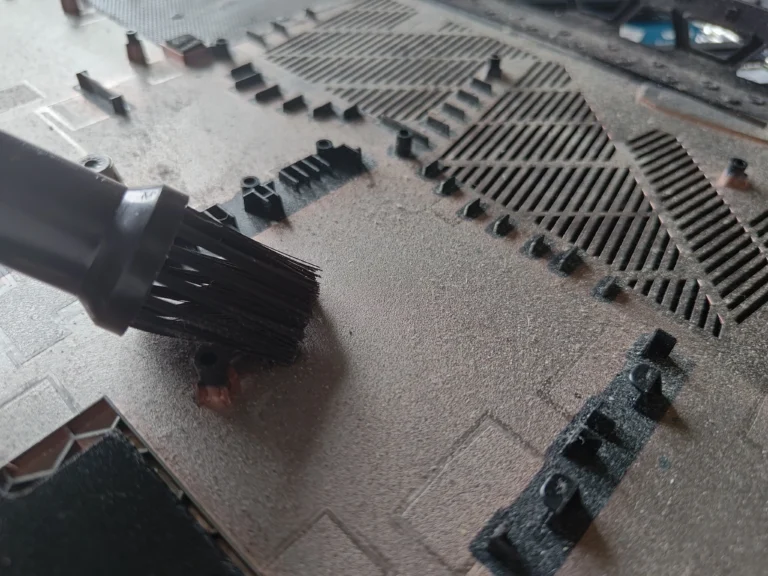 Dust being brushed from inside Acer Nitro AN517-51 lower-cover intake grille