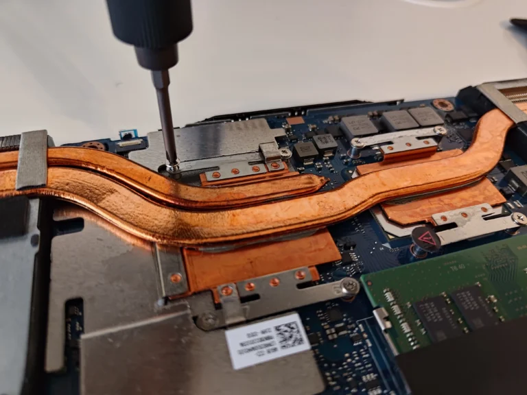 ASUS FX506LH copper heat-pipe assembly being secured during service