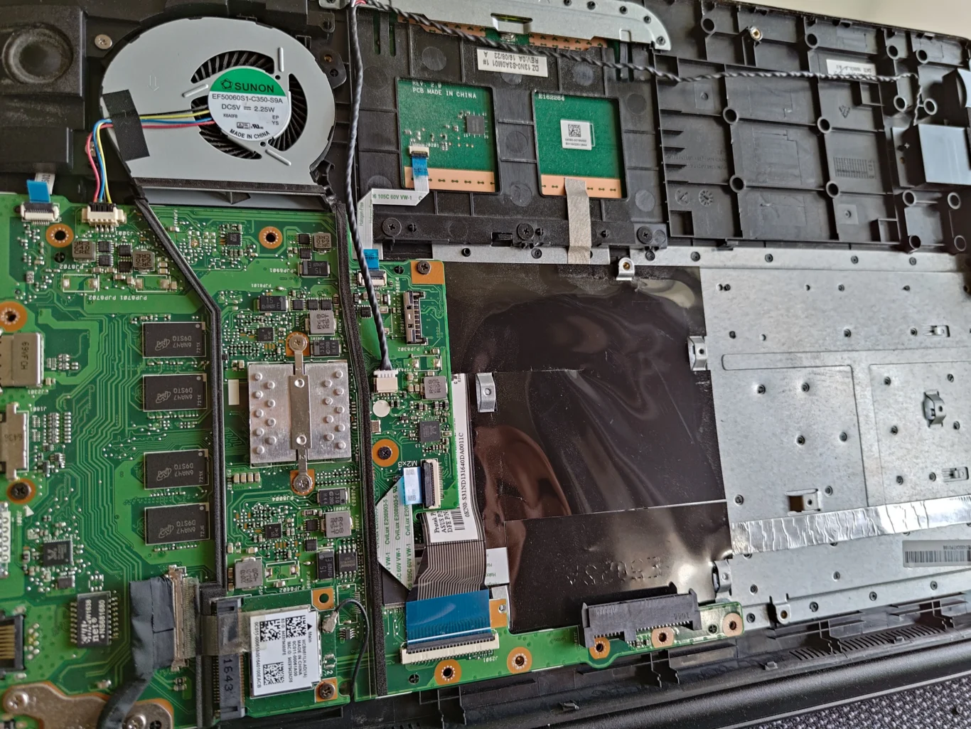 ASUS R517S opened to show single fan, motherboard and flat cable routes