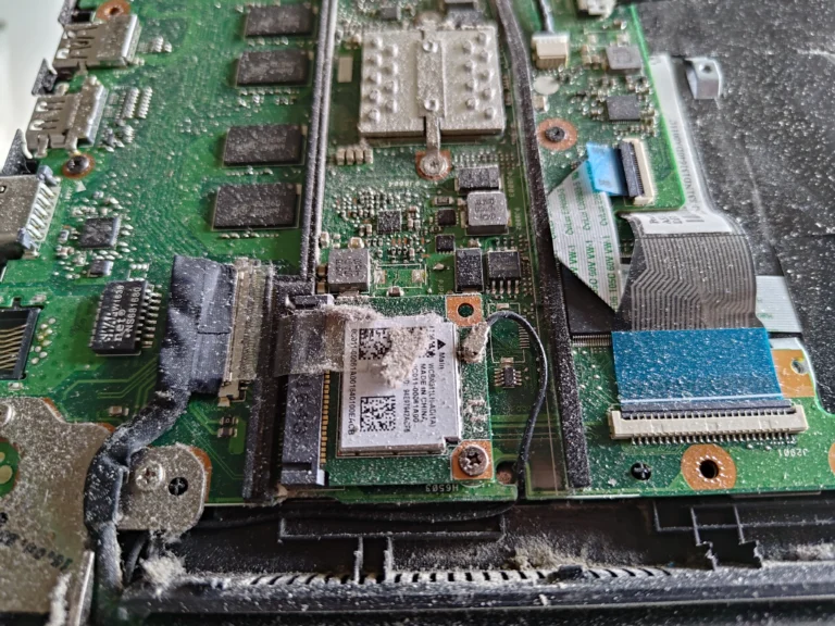 Close view of dusty Wi-Fi card and board area inside ASUS R517S