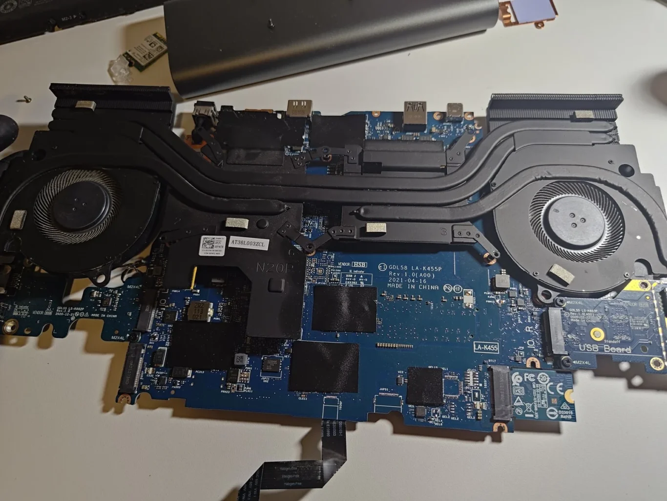 Dell G15 5511 motherboard removed from the laptop with two fans and connecting heat pipes still attached