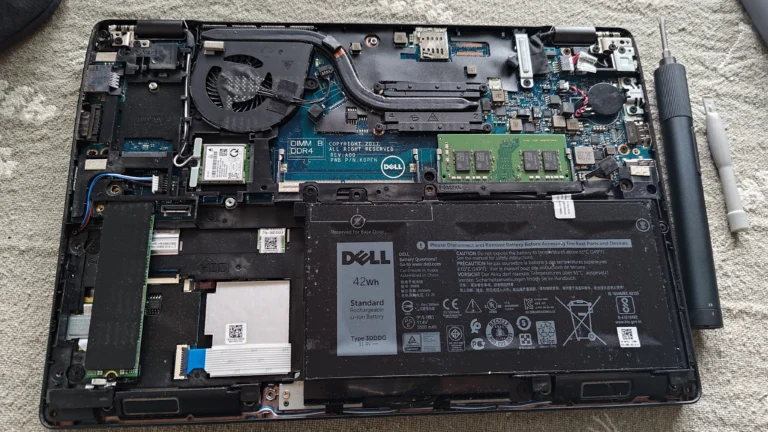 Open Dell Latitude showing battery, memory, Wi-Fi card and single-fan cooler