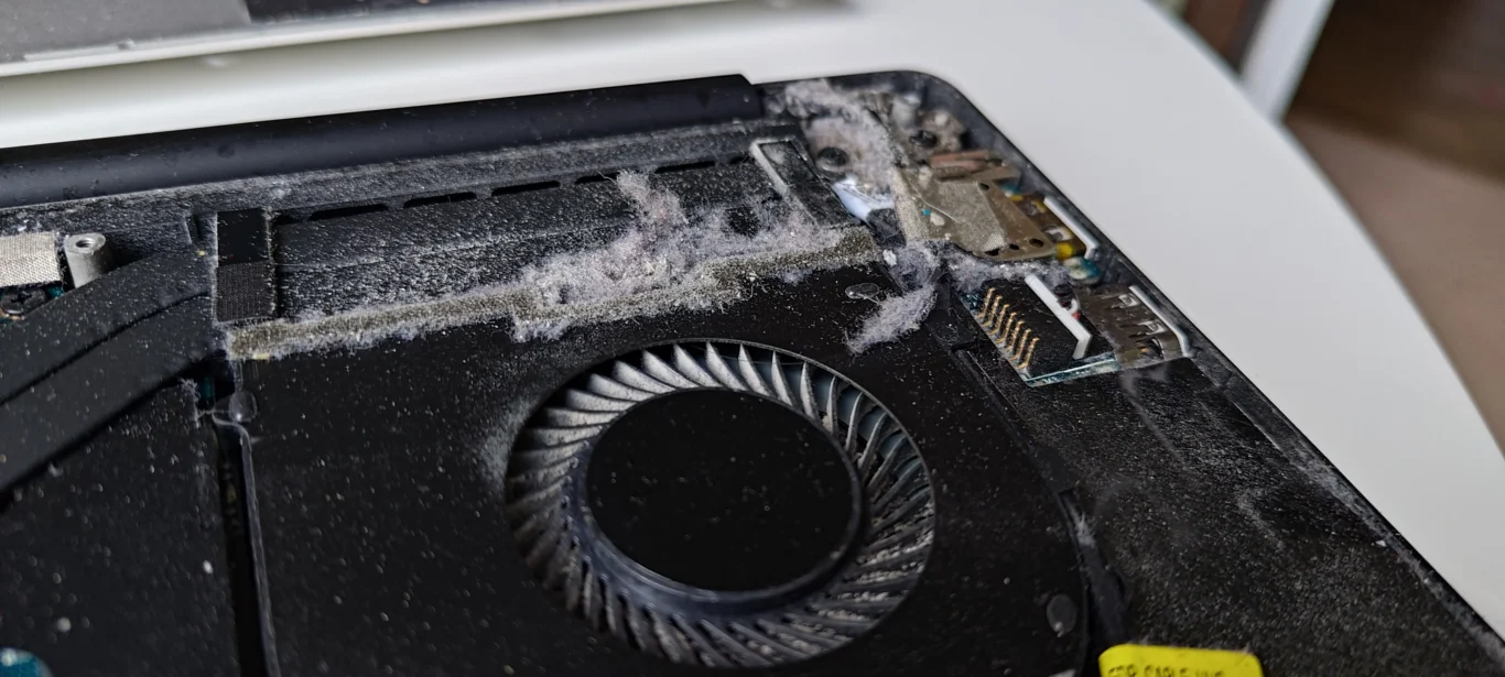 Fibres and dust gathered beside a Dell XPS blower fan and exhaust route
