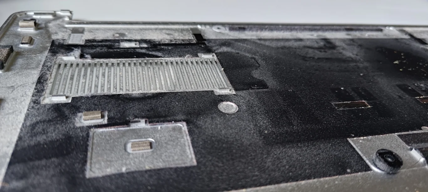 Dust film over the inside of a Dell XPS bottom-cover intake grille