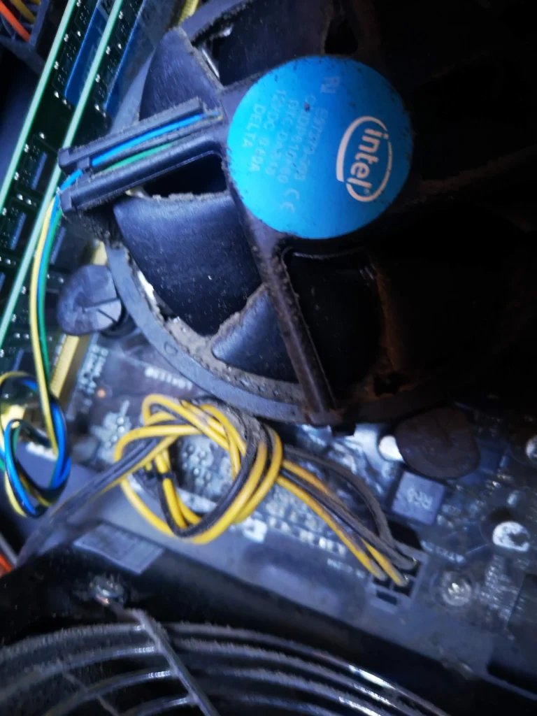 Intel CPU cooler and cables inside a dusty desktop tower