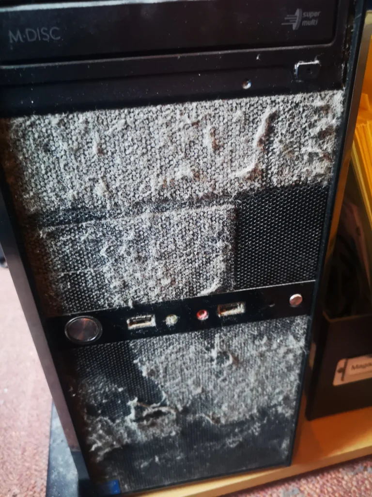 Desktop tower front intake heavily coated with dust before cleaning