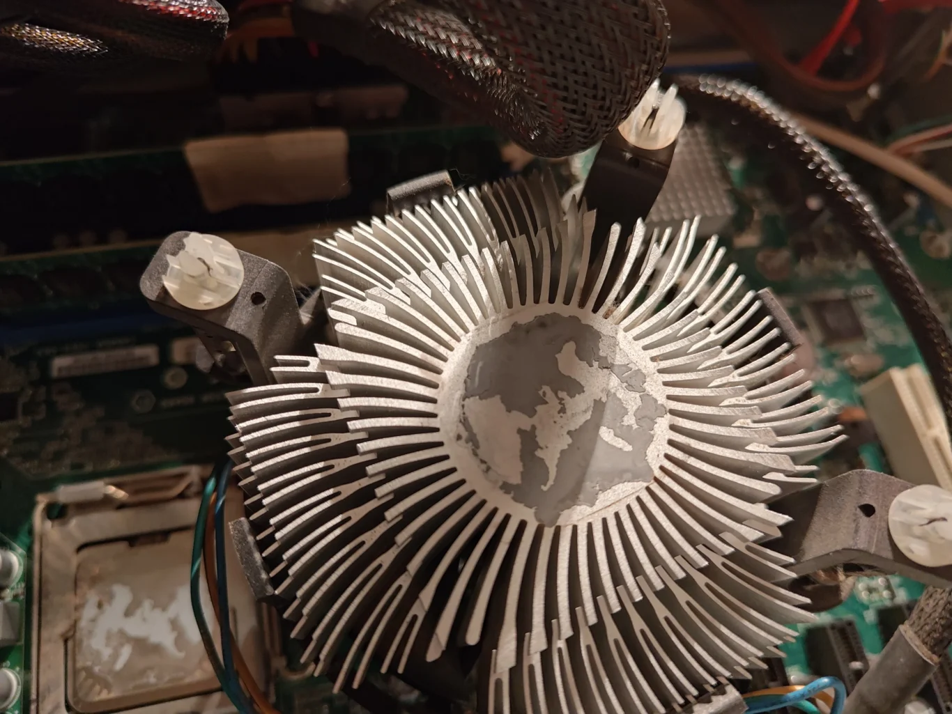 Underside of Intel radial CPU cooler showing old thermal compound on metal base