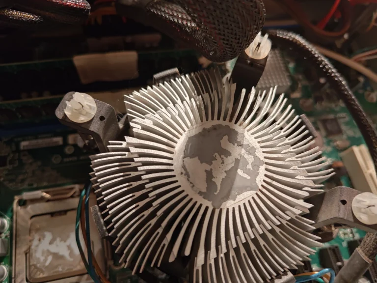 Underside of Intel radial CPU cooler showing old thermal compound on metal base