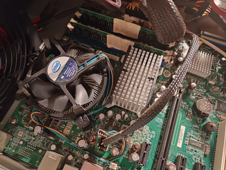 Intel CPU fan beside silver passive motherboard heatsink in older PC
