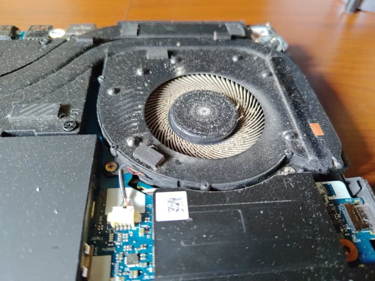 Dust-coated fan blades and housing inside a Lenovo Legion 5 Pro 16ITH6H