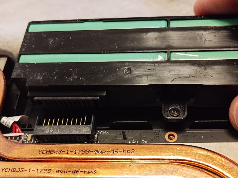 Close view of MSI GP72M 7REX battery connector beside copper heat pipes