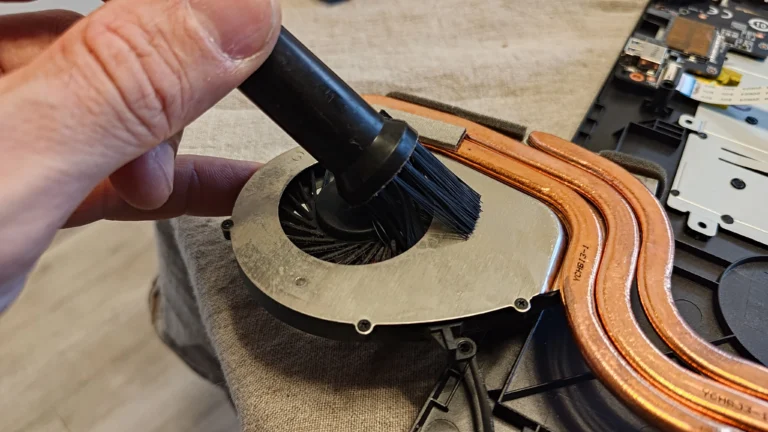 Engineer brushing dust from the MSI GP72M 7REX fan assembly