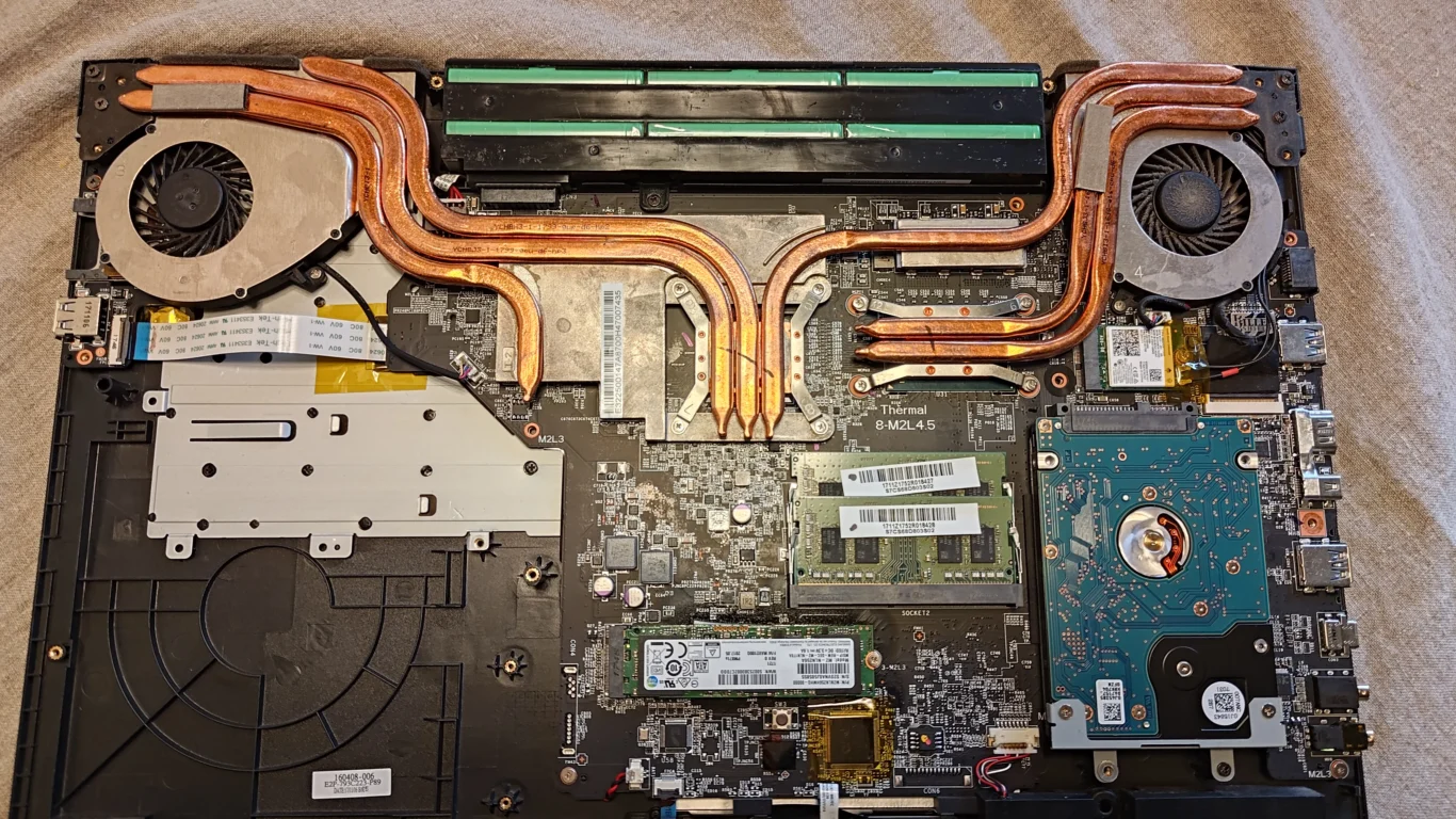 Inside the MSI GP72M 7REX with fans, copper heat pipes and battery visible