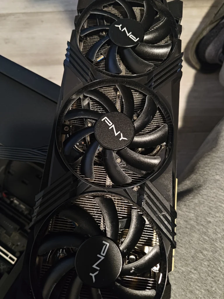 PNY GeForce RTX graphics card with three axial cooling fans removed from desktop