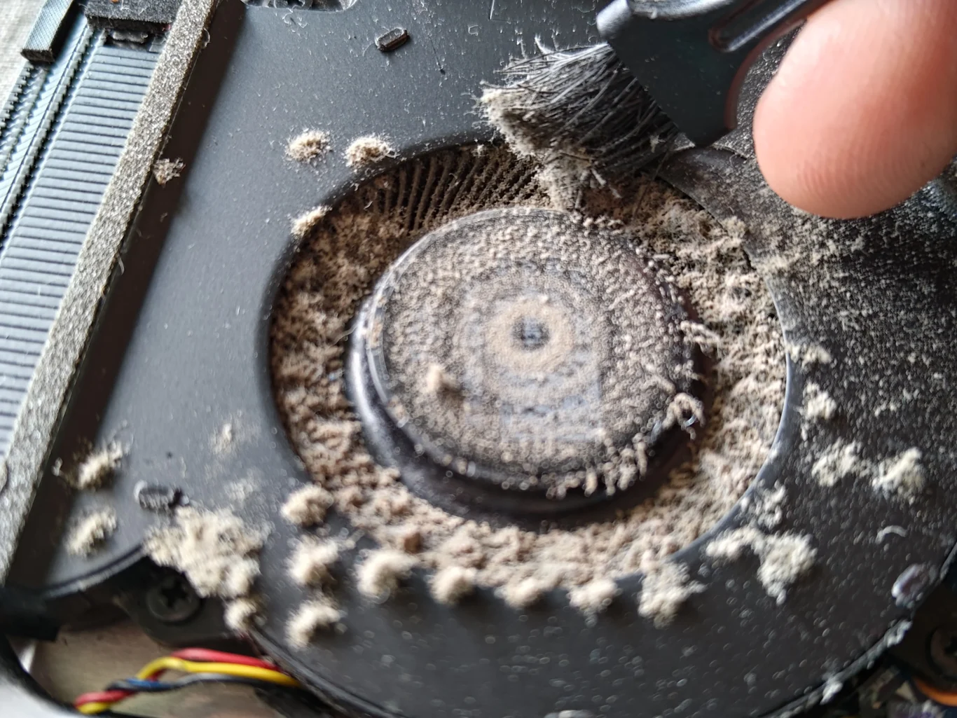 Brush lifting loose lint from ROG Strix G513RW fan inlet