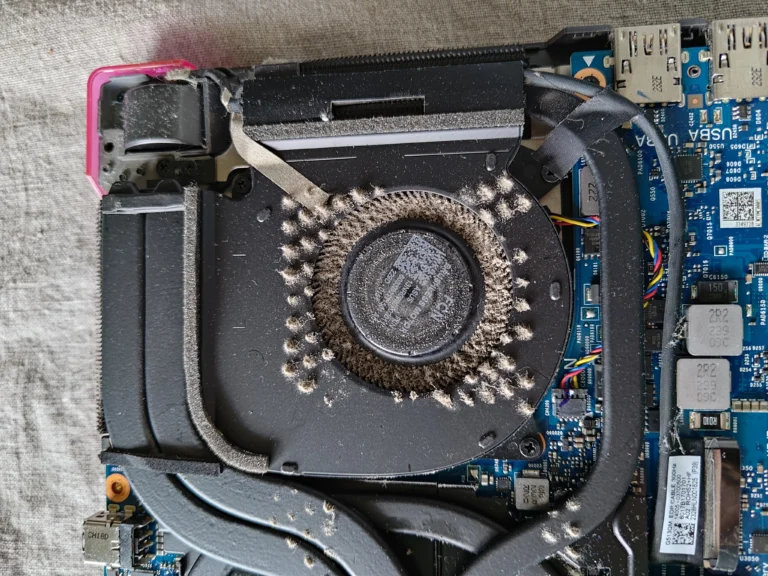 Before-cleaning close-up of lint packed around ROG Strix G513RW right fan