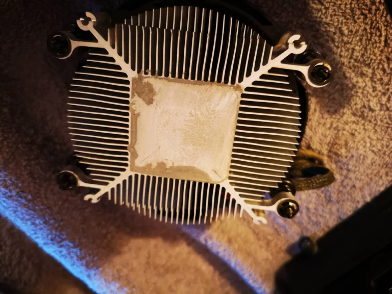 Underside of AMD CPU cooler with old thermal compound on the contact plate