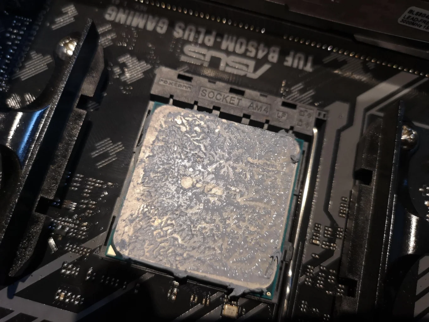 Old thermal compound visible on AMD Ryzen processor after tower cooler removal