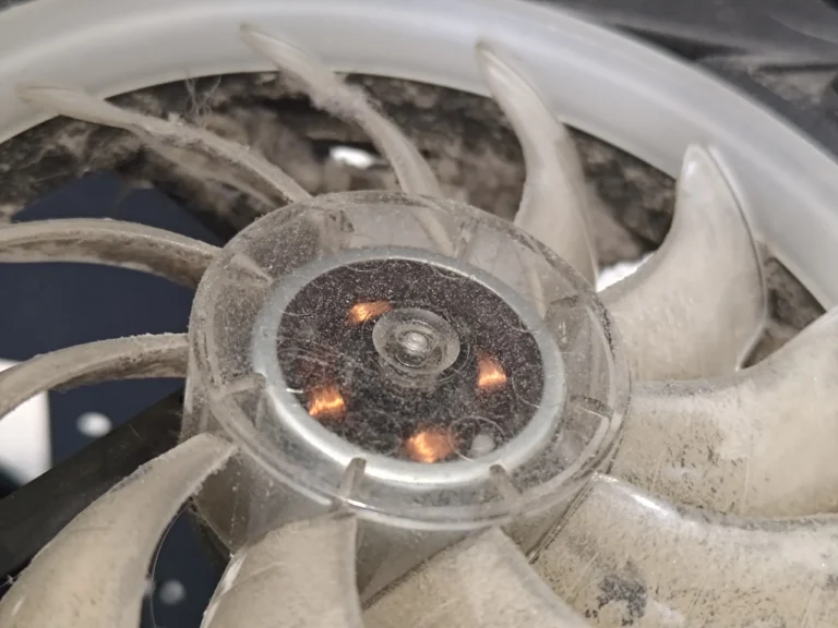 Close-up of dust on white desktop fan hub and blades